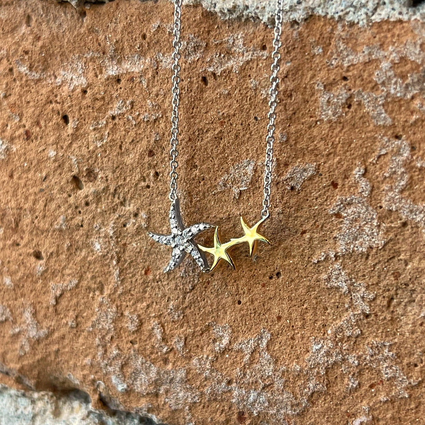 Photo of Zeghani Starfish Necklace in a decorative scene, designed by , available at Plumb Gold & Plumb Silver