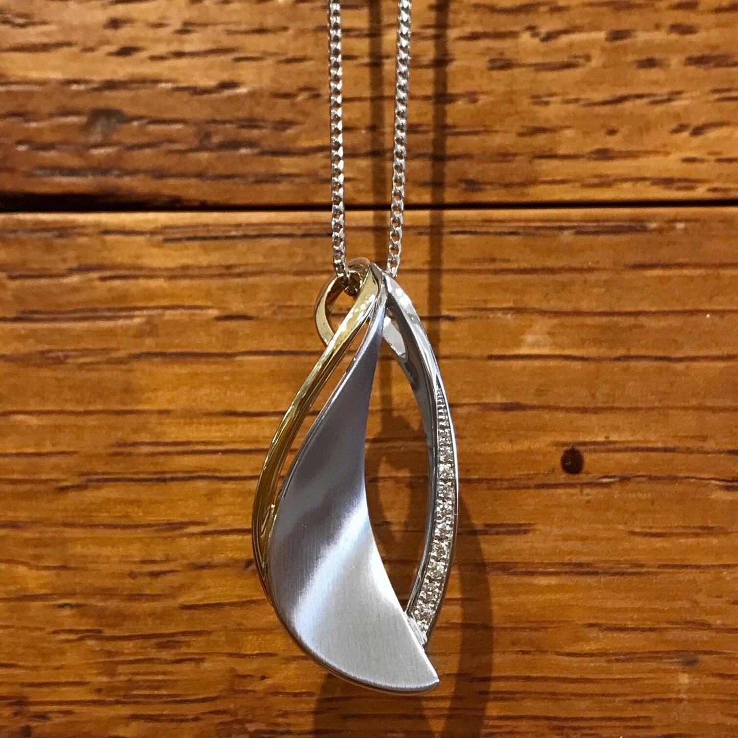 Photo of Abstract Leaf Pendant in a decorative scene, designed by , available at Plumb Gold & Plumb Silver