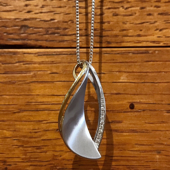 Photo of Abstract Leaf Pendant in a decorative scene, designed by , available at Plumb Gold & Plumb Silver