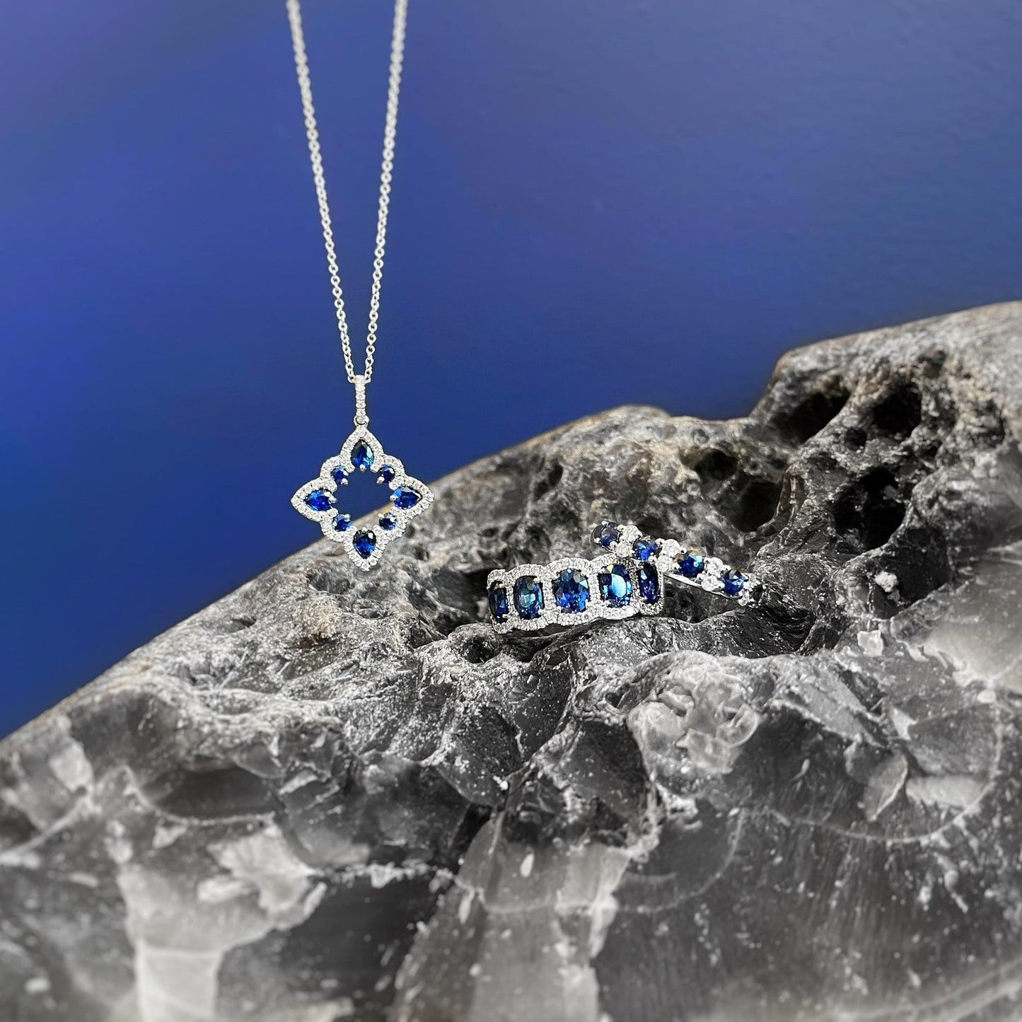 Photo of Alternating Blue Sapphire and Diamond Ring in a decorative scene, designed by , available at Plumb Gold & Plumb Silver