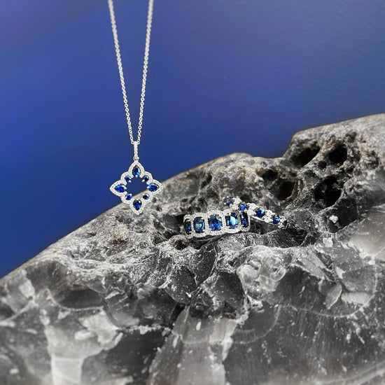 Photo of Alternating Blue Sapphire and Diamond Ring in a decorative scene, designed by , available at Plumb Gold & Plumb Silver