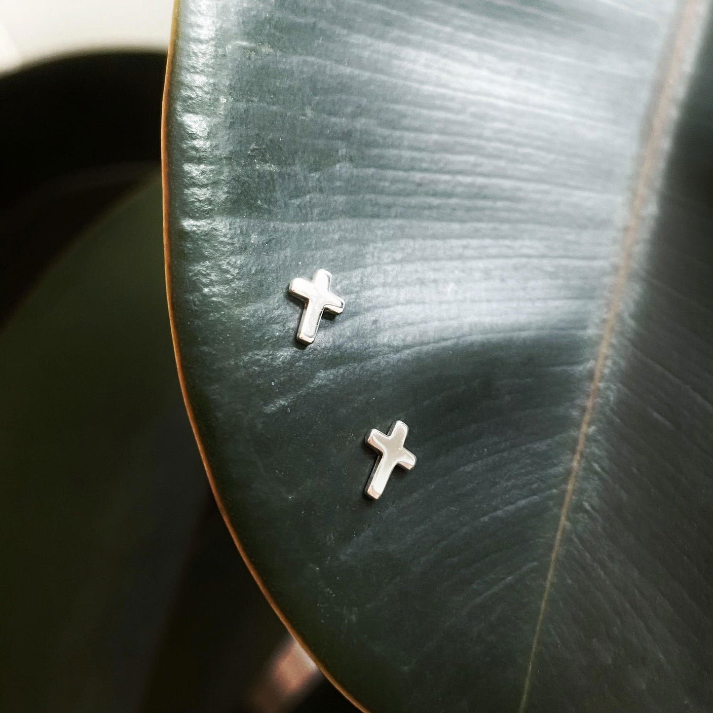 Photo of Baby Cross Studs in a decorative scene, designed by , available at Plumb Gold & Plumb Silver