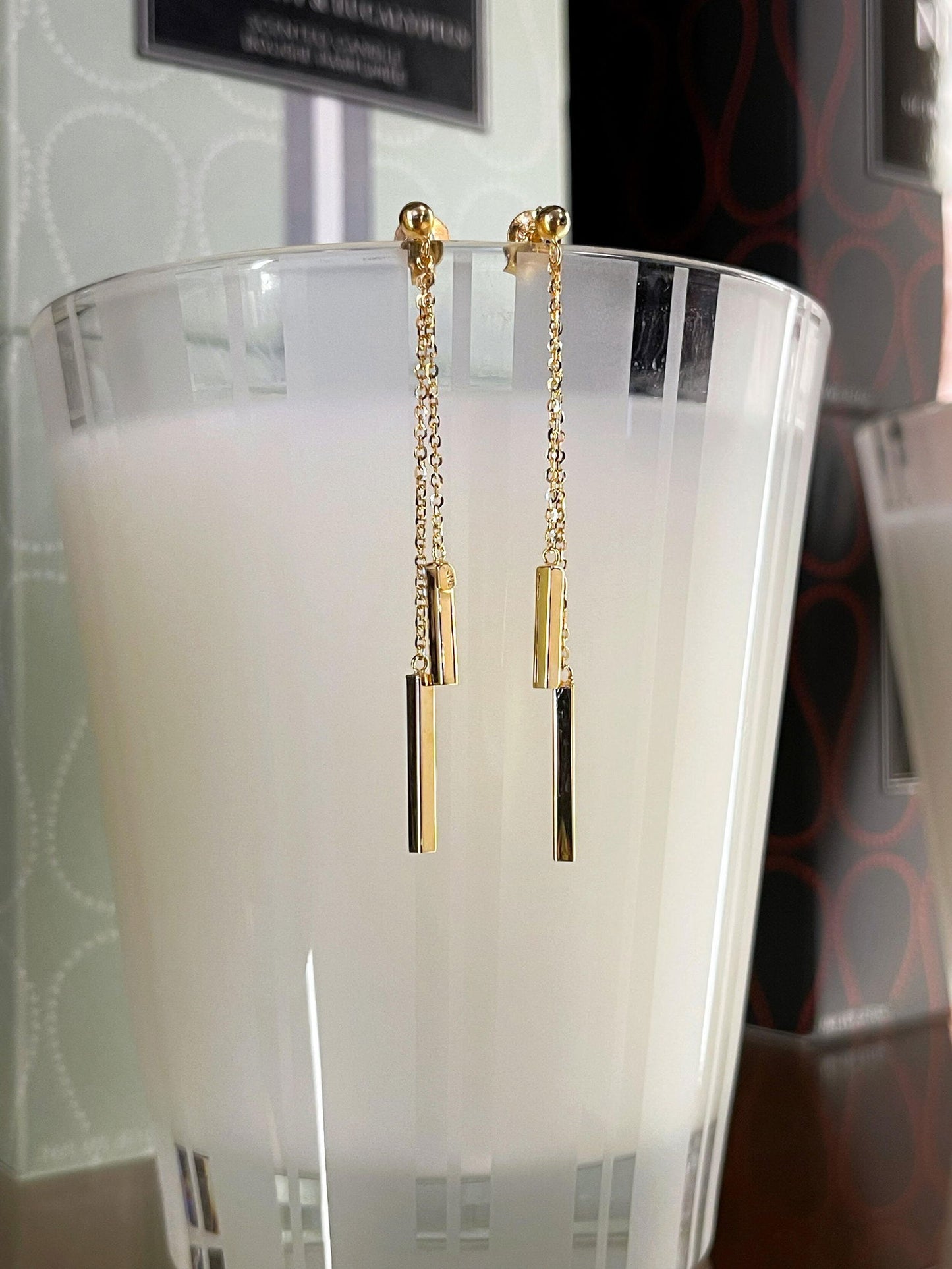 Photo of Bar Dangle Earrings in a decorative scene, designed by , available at Plumb Gold & Plumb Silver