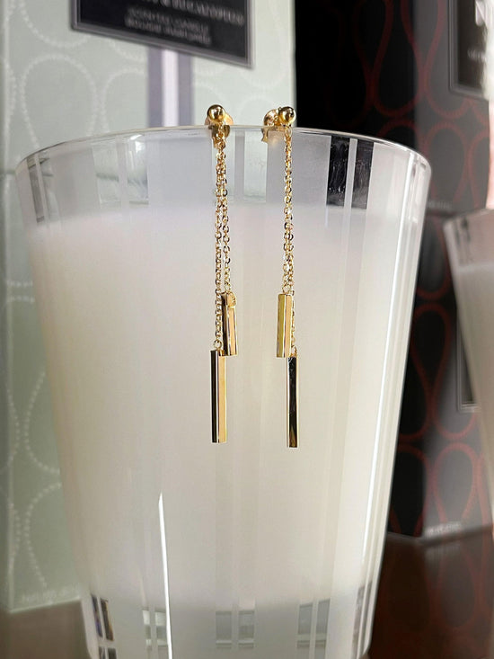 Photo of Bar Dangle Earrings in a decorative scene, designed by , available at Plumb Gold & Plumb Silver
