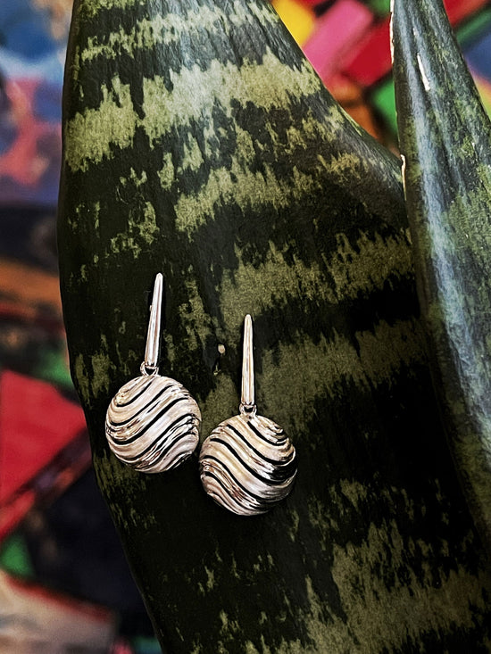 Photo of "Bay" Dangles in a decorative scene, designed by , available at Plumb Gold & Plumb Silver