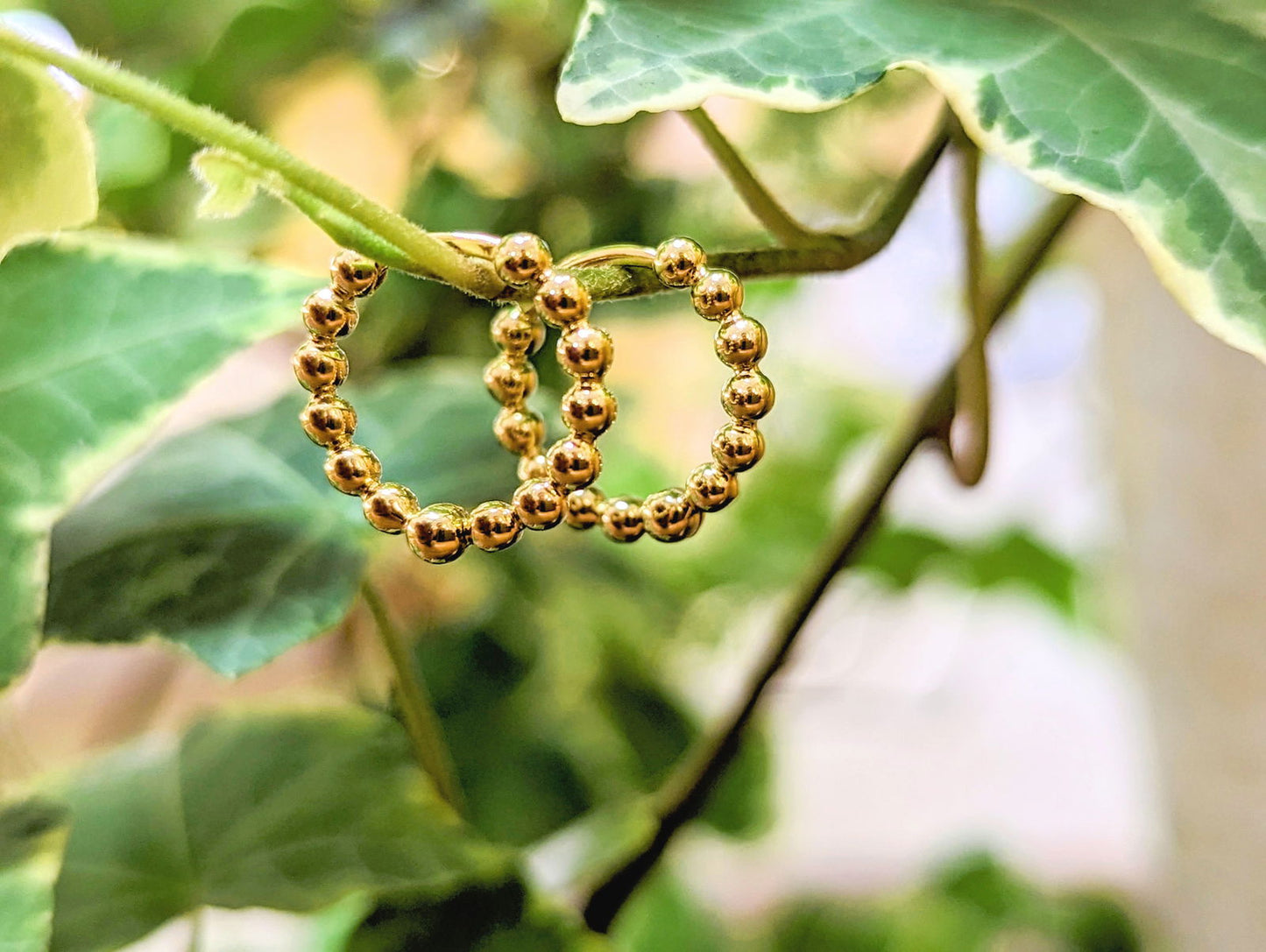 Photo of Bead Hinged Hoops in a decorative scene, designed by , available at Plumb Gold & Plumb Silver