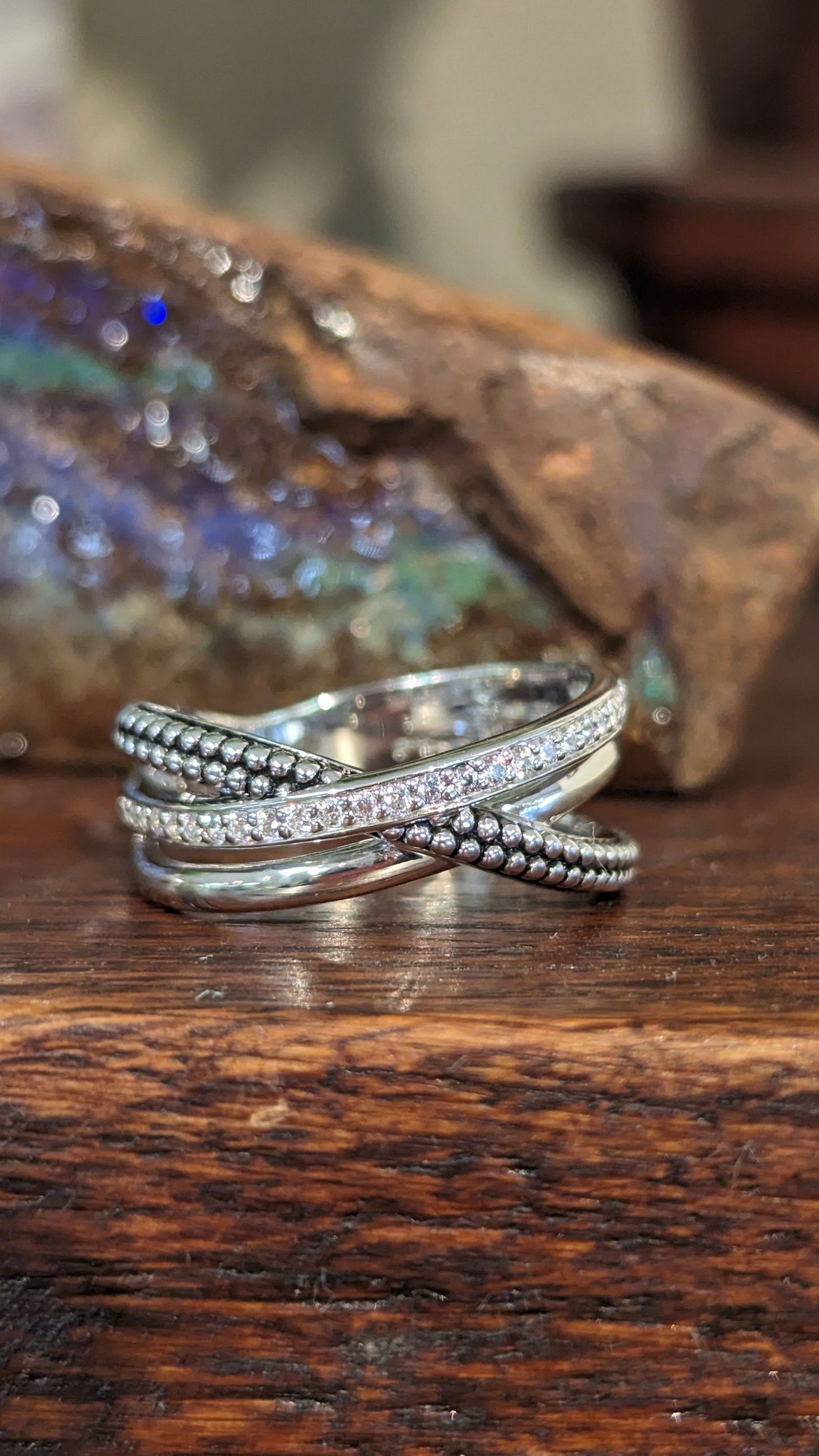 Photo of Beaded Cubic Zirconia Crossover Ring in a decorative scene, designed by , available at Plumb Gold & Plumb Silver