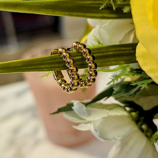 Photo of Beaded Hoop Earrings in a decorative scene, designed by , available at Plumb Gold & Plumb Silver