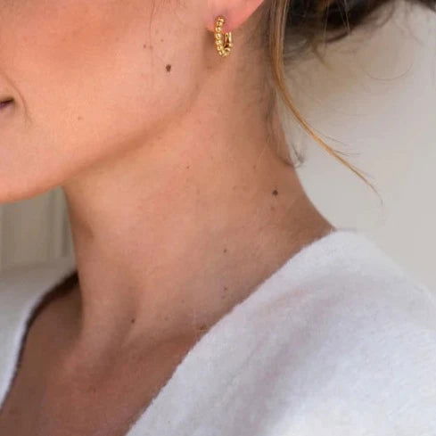 Photo of Beaded Hoop Earrings in a decorative scene, designed by , available at Plumb Gold & Plumb Silver