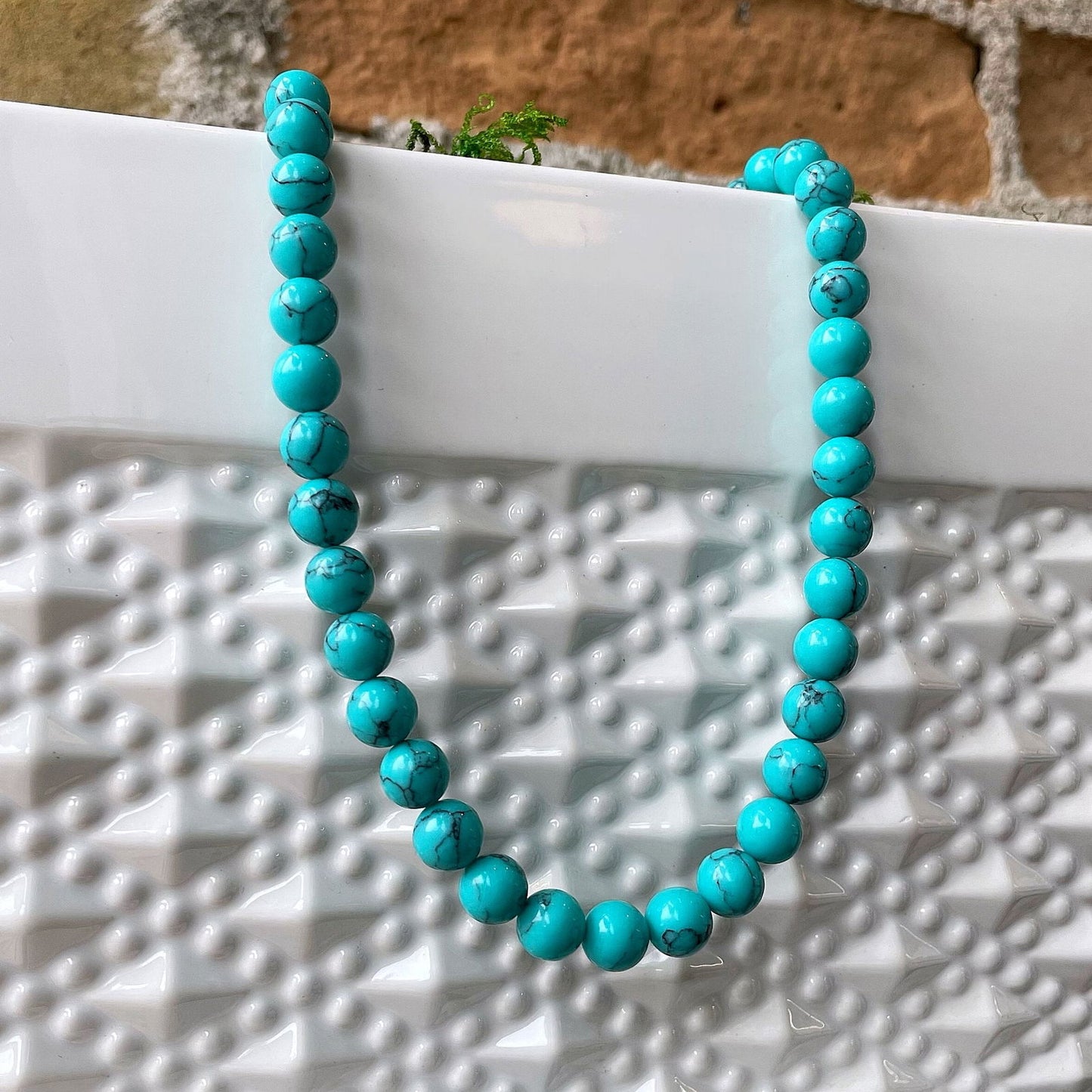 Photo of Beaded Turquoise Necklace in a decorative scene, designed by , available at Plumb Gold & Plumb Silver