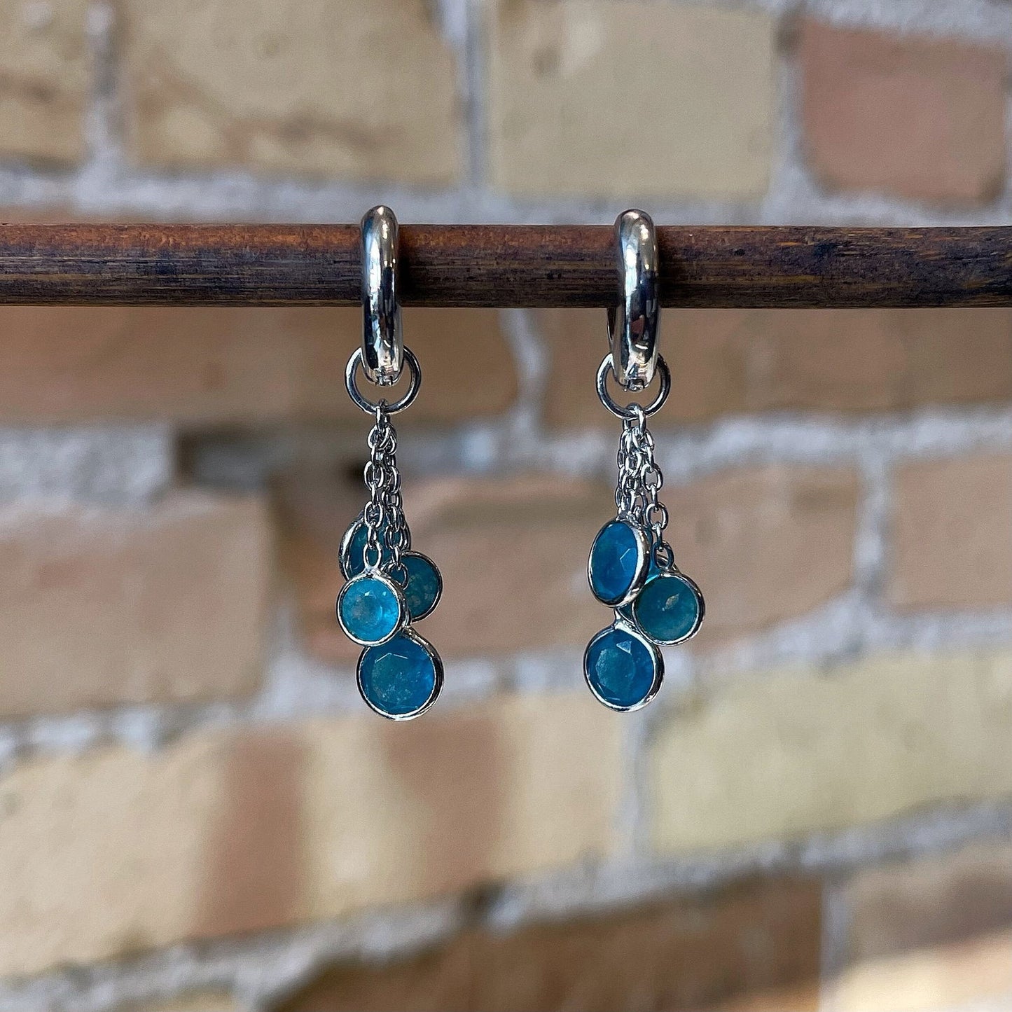 Photo of “Bella” Apatite Dangles in a decorative scene, designed by , available at Plumb Gold & Plumb Silver