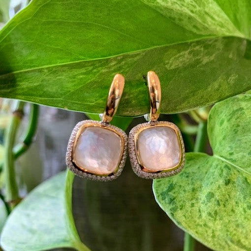 Photo of Bezel CZ Pave Halo Earrings in a decorative scene, designed by , available at Plumb Gold & Plumb Silver