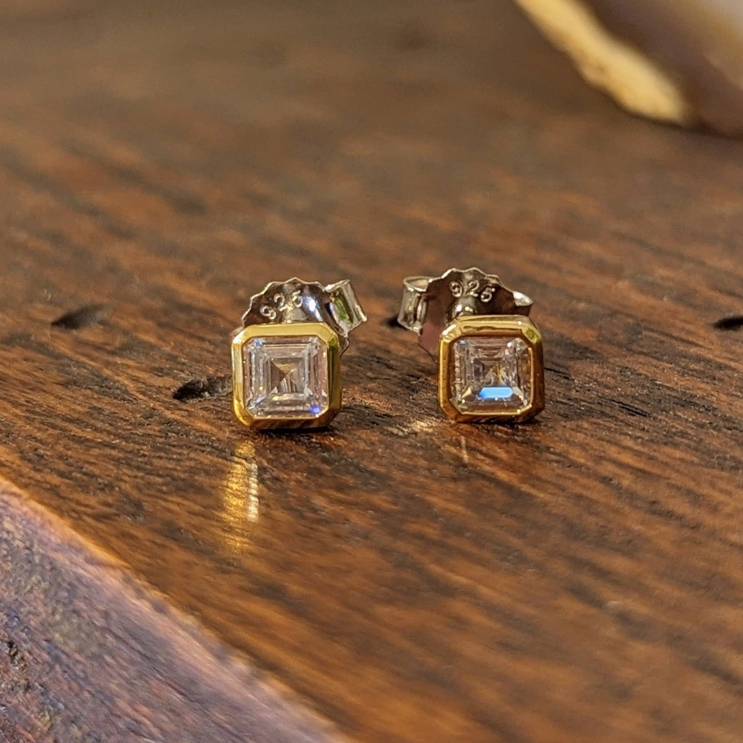 Photo of Bezel CZ Step Cut Studs in a decorative scene, designed by , available at Plumb Gold & Plumb Silver