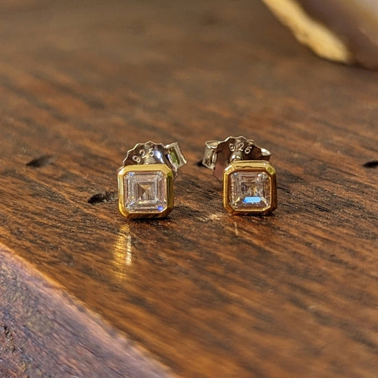 Photo of Bezel CZ Step Cut Studs in a decorative scene, designed by , available at Plumb Gold & Plumb Silver