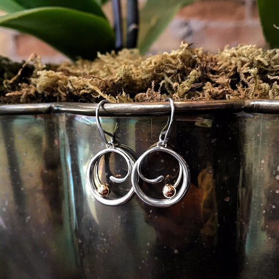 Photo of "Bindu" Earrings in a decorative scene, designed by , available at Plumb Gold & Plumb Silver