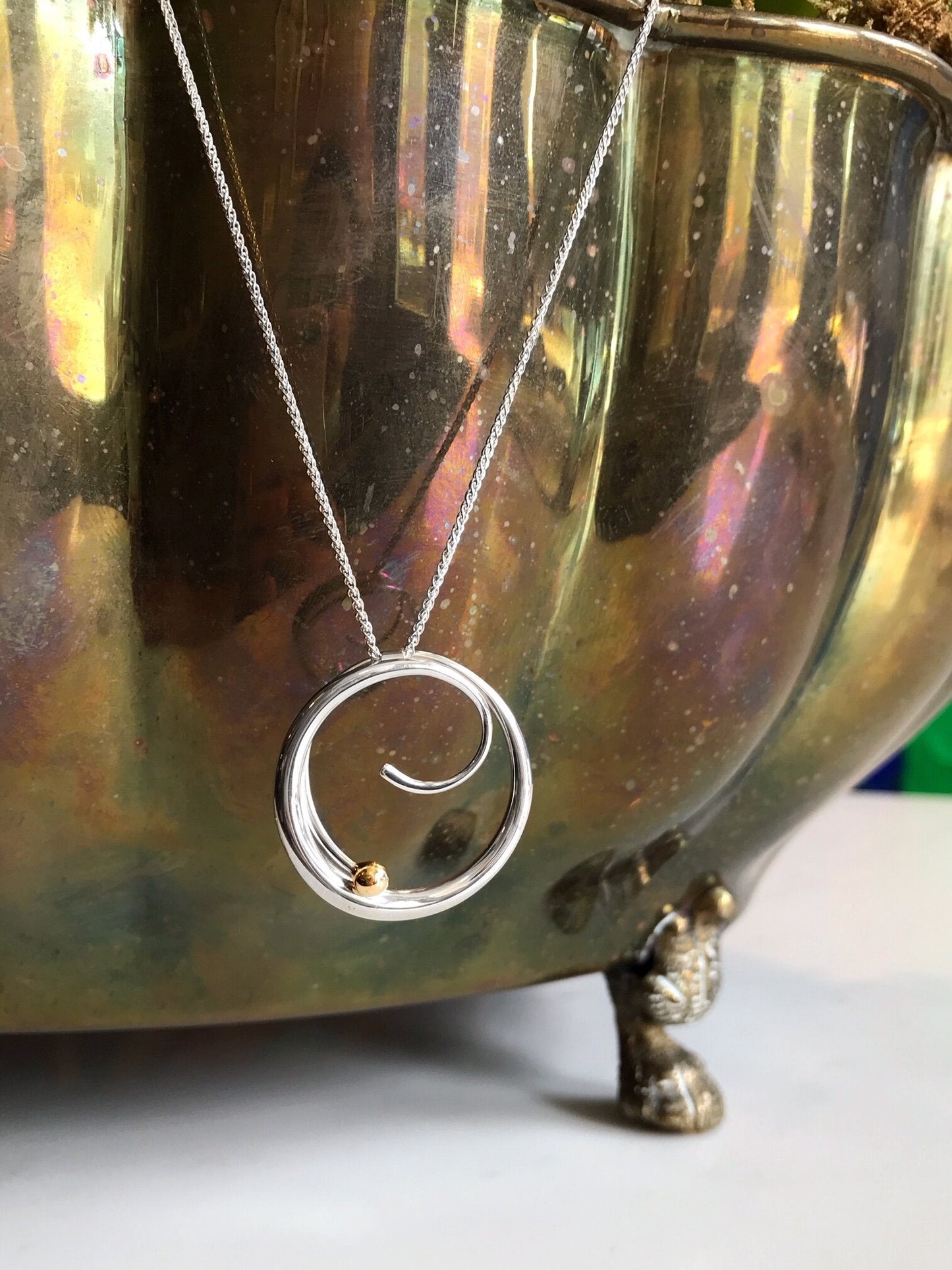 Photo of "Bindu" Necklace in a decorative scene, designed by , available at Plumb Gold & Plumb Silver