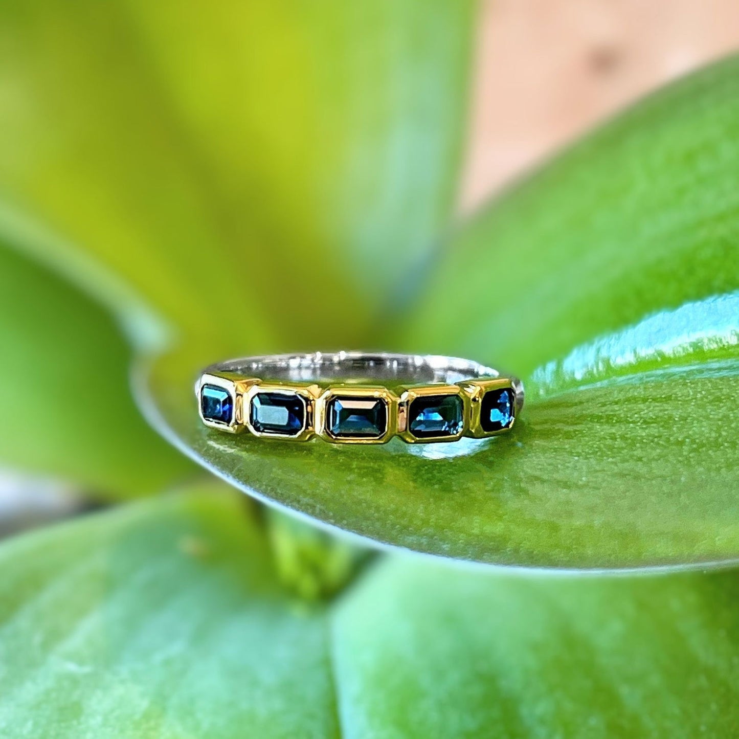 Photo of Blue Emerald-Cut Cubic Zirconia Ring in a decorative scene, designed by , available at Plumb Gold & Plumb Silver
