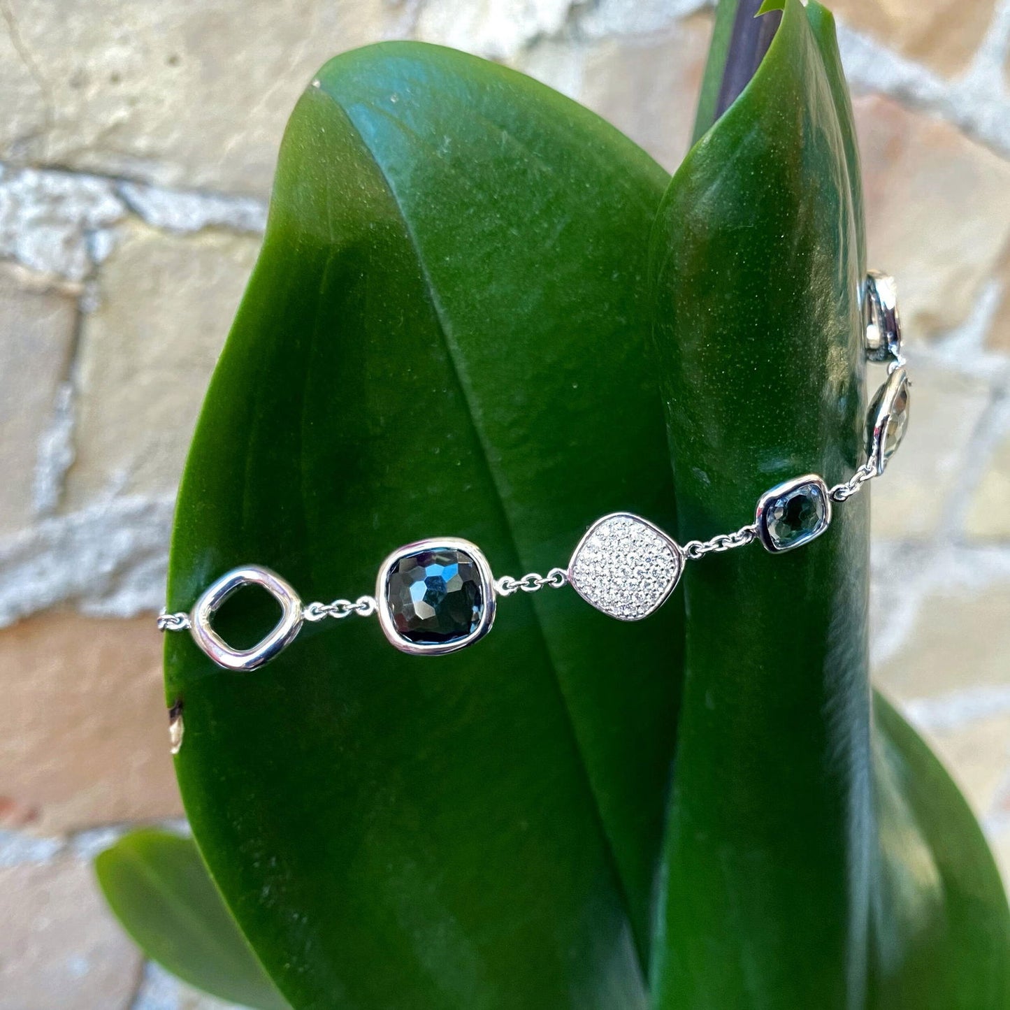 Photo of Blue Quartz and Cubic Zirconia Station Bracelet in a decorative scene, designed by , available at Plumb Gold & Plumb Silver