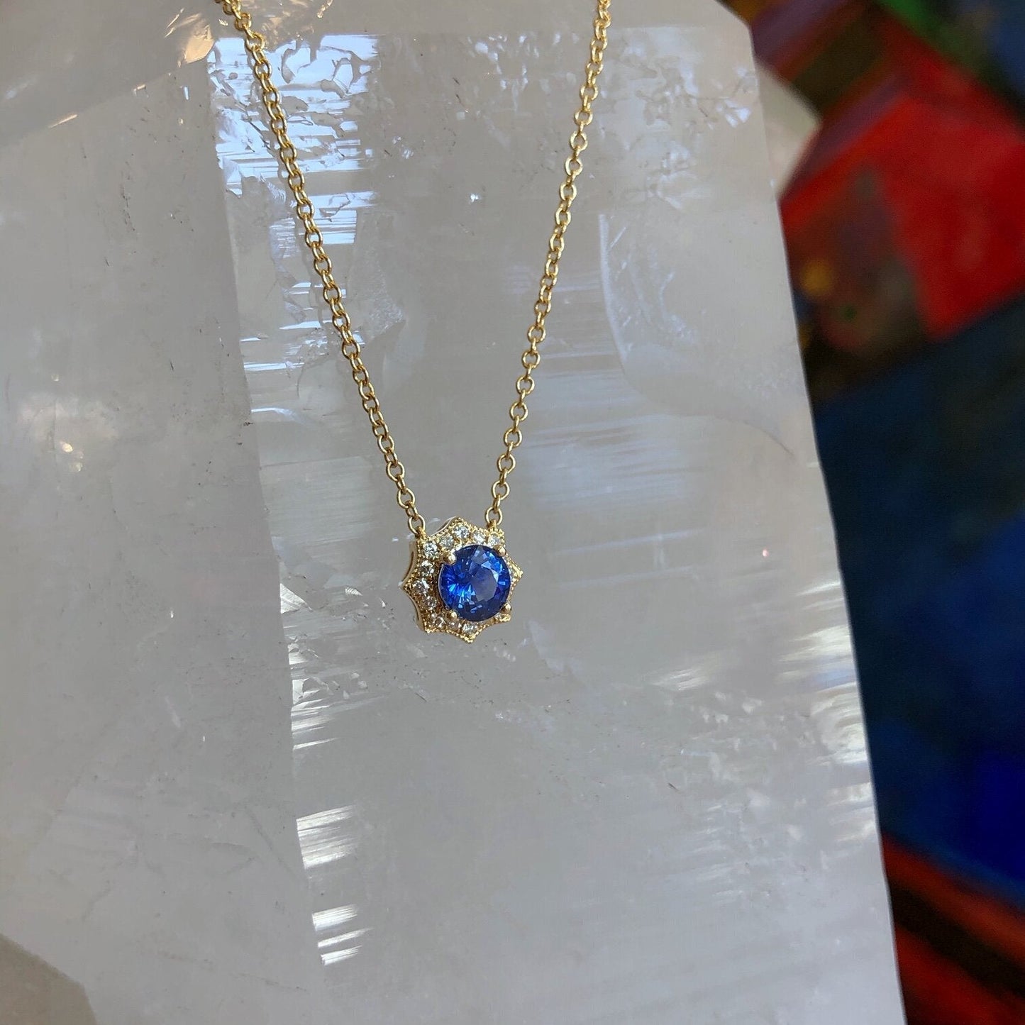 Photo of Blue Sapphire and Diamond Web Necklace in a decorative scene, designed by , available at Plumb Gold & Plumb Silver