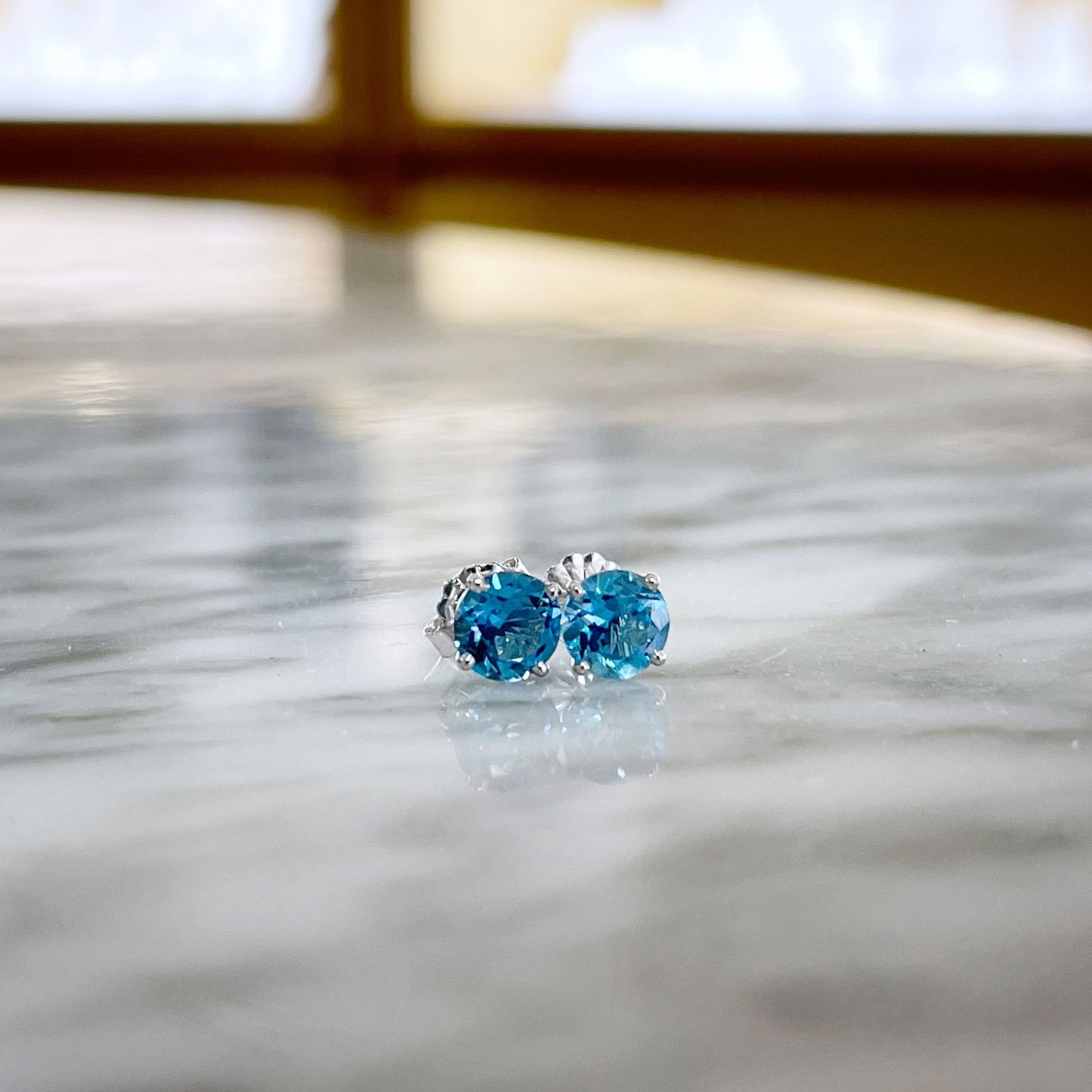 Photo of Blue Topaz Studs in a decorative scene, designed by , available at Plumb Gold & Plumb Silver