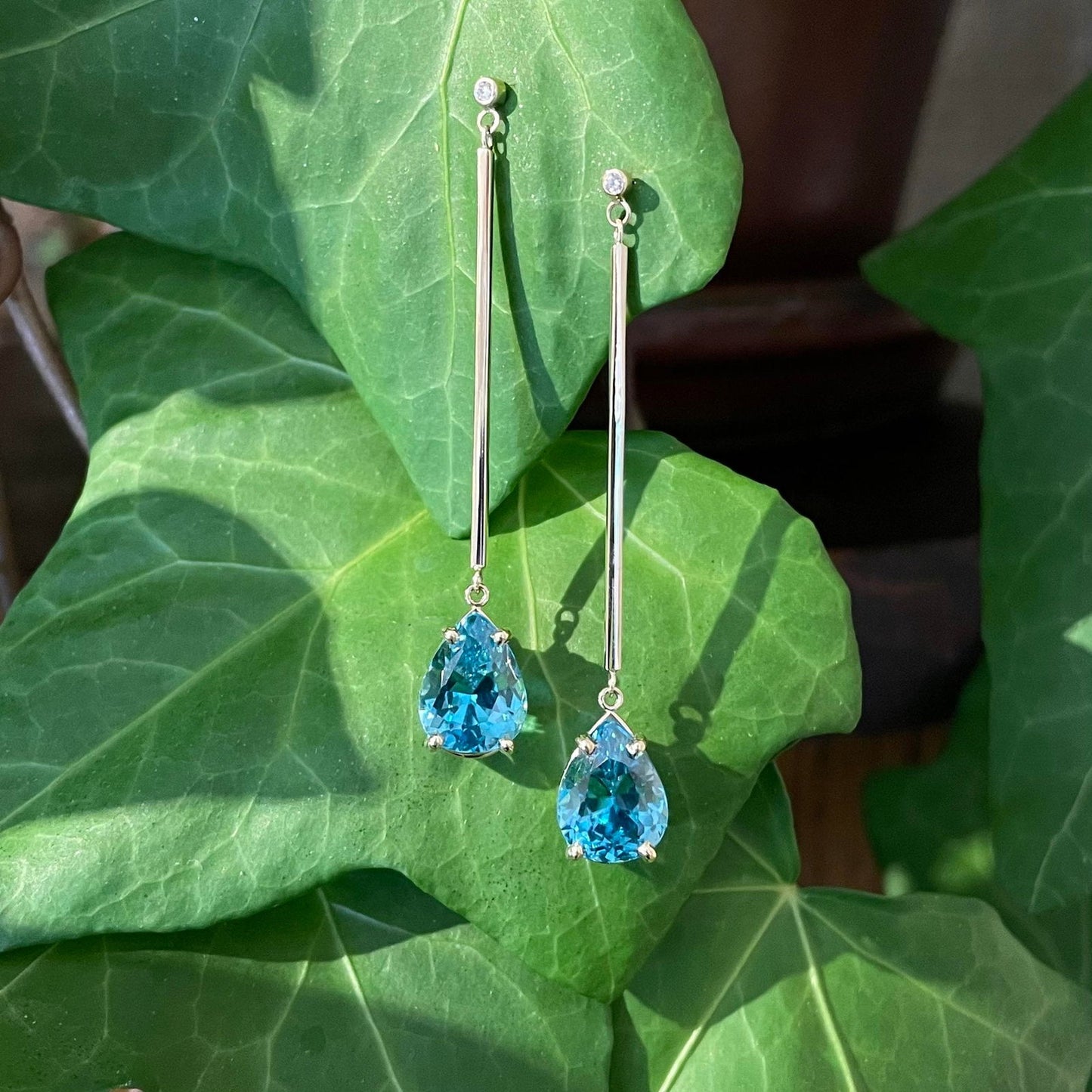 Photo of Blue Zircon Diamond Dangles in a decorative scene, designed by , available at Plumb Gold & Plumb Silver