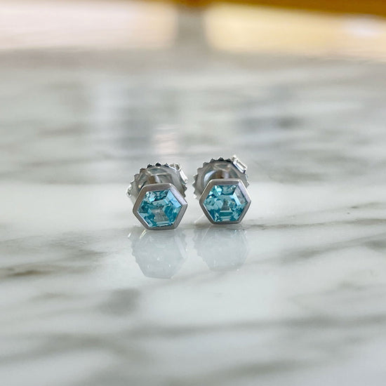 Photo of Blue Zircon Hexagon Studs in a decorative scene, designed by , available at Plumb Gold & Plumb Silver