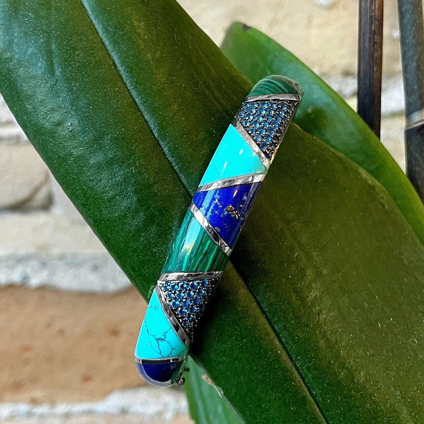 Photo of Blue and Green Inlay Bracelet in a decorative scene, designed by , available at Plumb Gold & Plumb Silver