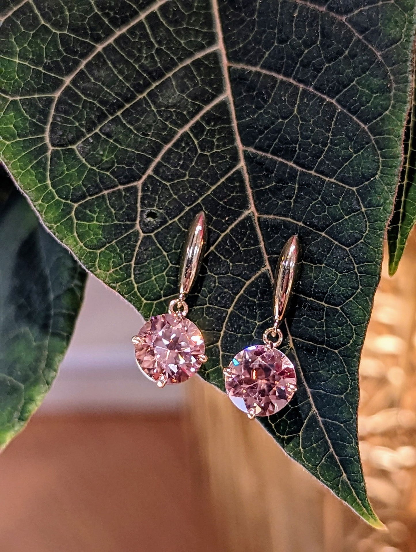 Photo of Blush Zircon Dangle Earrings in a decorative scene, designed by , available at Plumb Gold & Plumb Silver