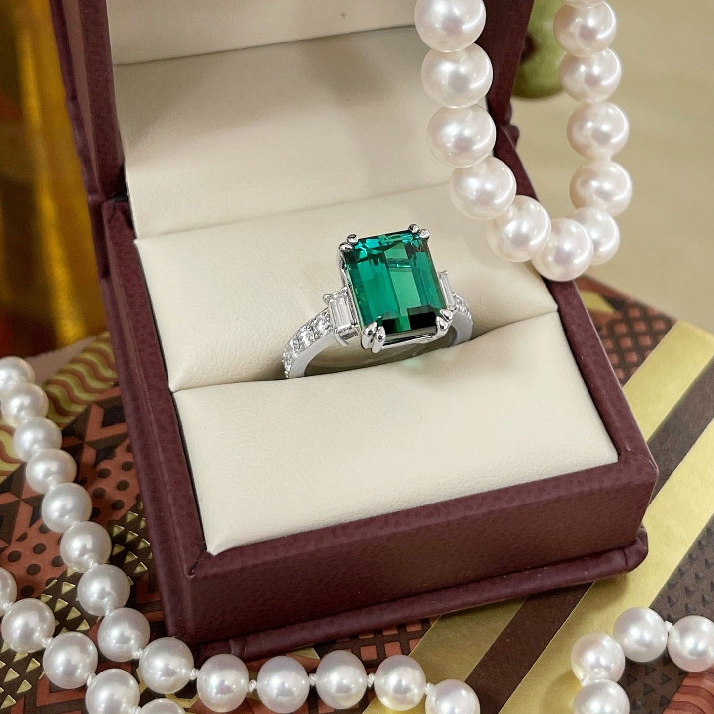 Photo of Bold Emerald Cut Tourmaline Ring in a decorative scene, designed by , available at Plumb Gold & Plumb Silver