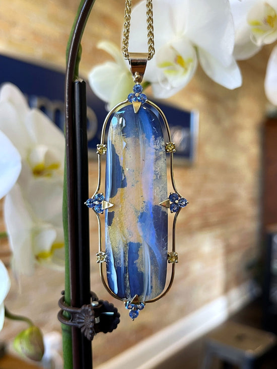 Photo of Boulder Opal Pendant in a decorative scene, designed by , available at Plumb Gold & Plumb Silver