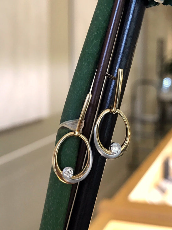 Photo of Breuning Oval Swoop Earrings in a decorative scene, designed by , available at Plumb Gold & Plumb Silver