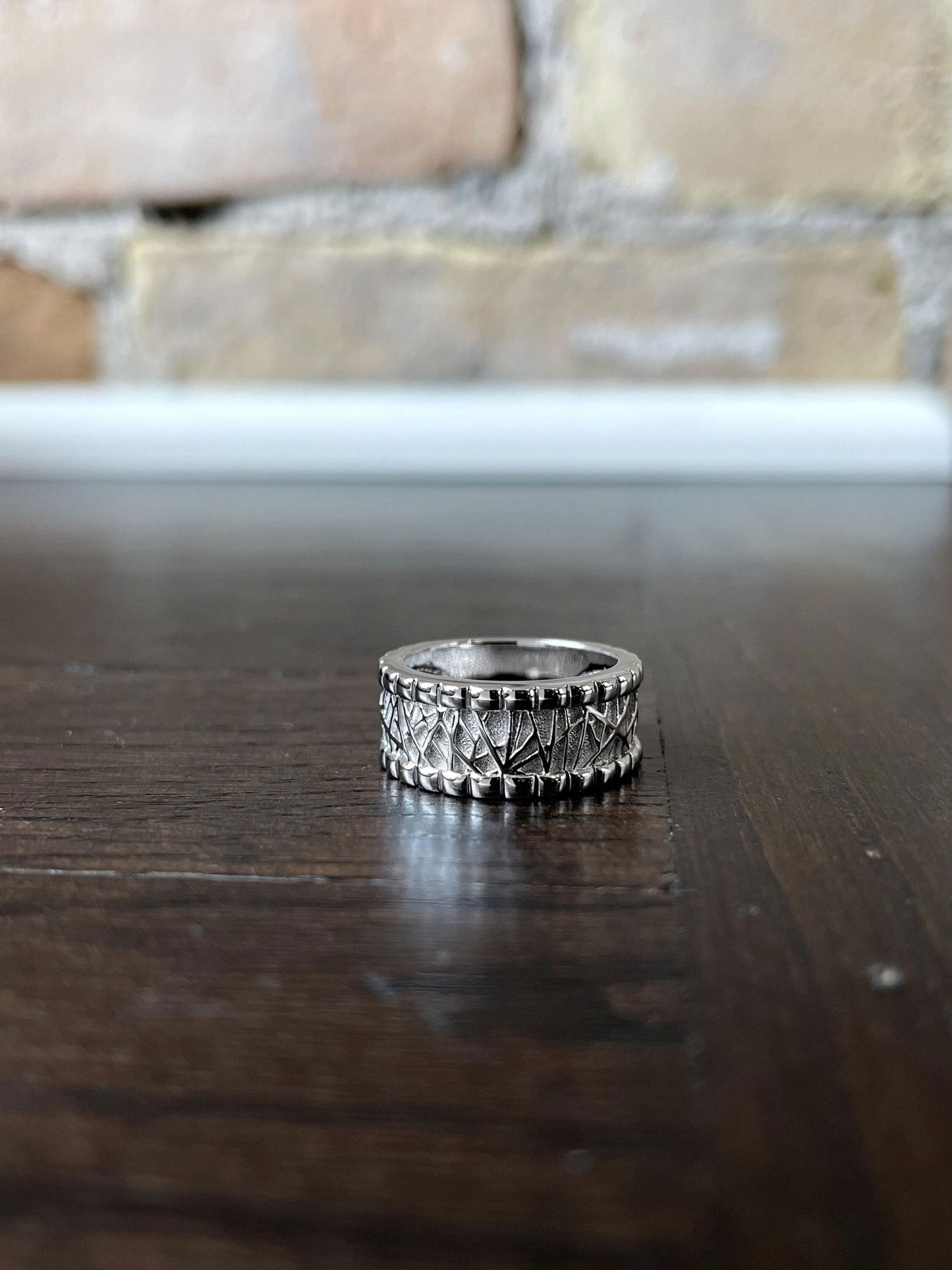 Photo of Breuning Textured Ring in a decorative scene, designed by , available at Plumb Gold & Plumb Silver