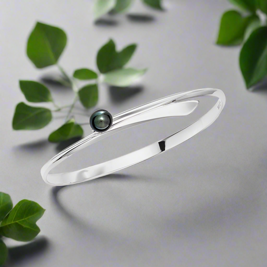 Photo of "Button" Swing Bracelet in a decorative scene, designed by , available at Plumb Gold & Plumb Silver