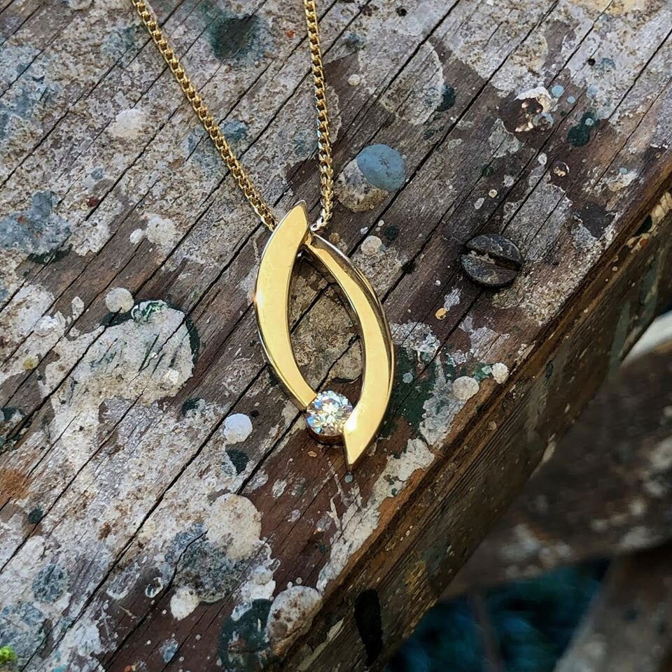 Photo of Bypass Diamond Pendant in a decorative scene, designed by , available at Plumb Gold & Plumb Silver
