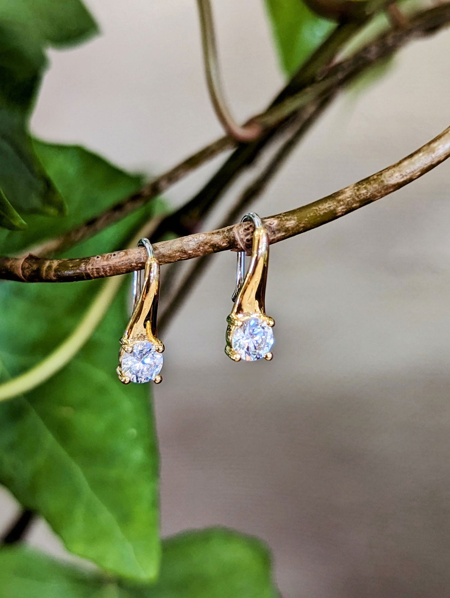 Photo of CZ Drop Earrings in a decorative scene, designed by , available at Plumb Gold & Plumb Silver