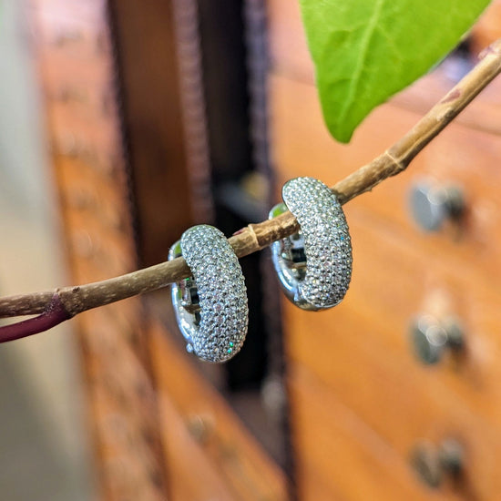 Photo of CZ Pavé Hoop in a decorative scene, designed by , available at Plumb Gold & Plumb Silver