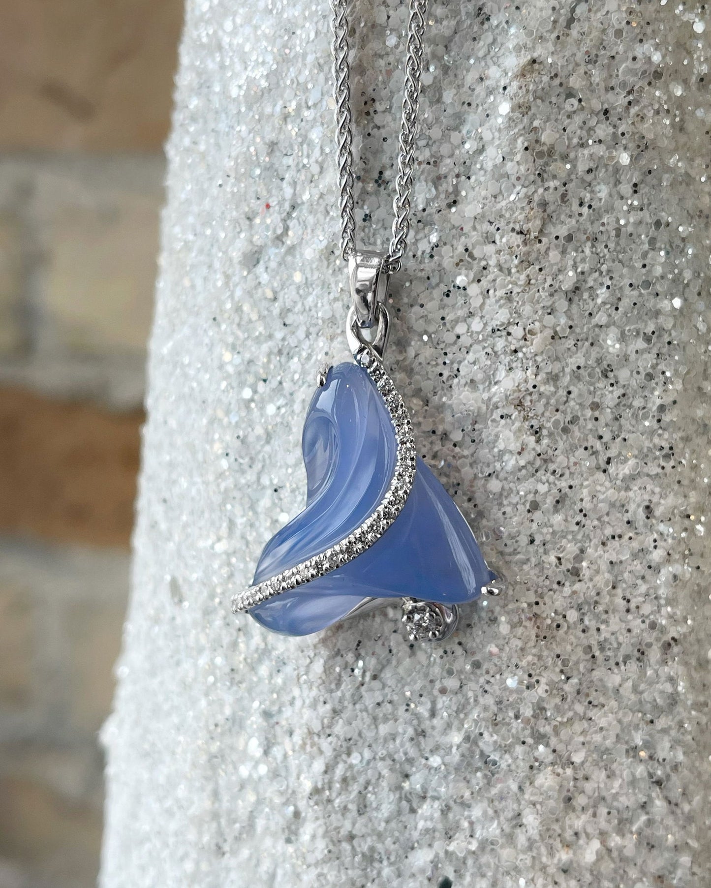 Photo of Carved Chalcedony Pendant in a decorative scene, designed by , available at Plumb Gold & Plumb Silver