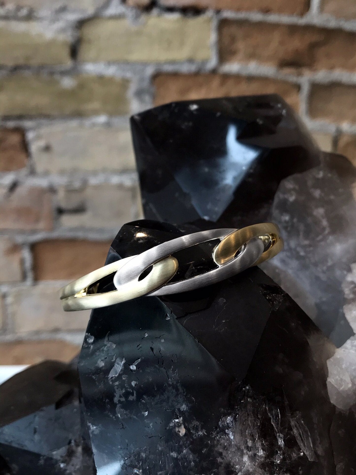 Photo of Chain Link Bangle in a decorative scene, designed by , available at Plumb Gold & Plumb Silver
