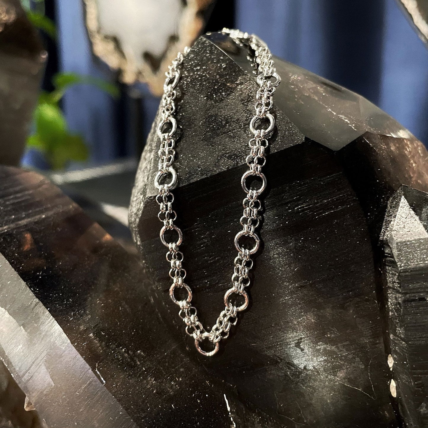 Photo of Chain Mail Cable Link Bracelet in a decorative scene, designed by , available at Plumb Gold & Plumb Silver