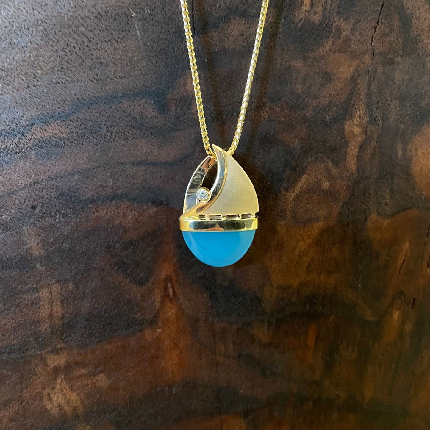 Photo of Chalcedony Pendant in a decorative scene, designed by , available at Plumb Gold & Plumb Silver