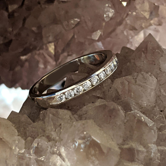 Photo of Channel Set Diamond Ring in a decorative scene, designed by , available at Plumb Gold & Plumb Silver