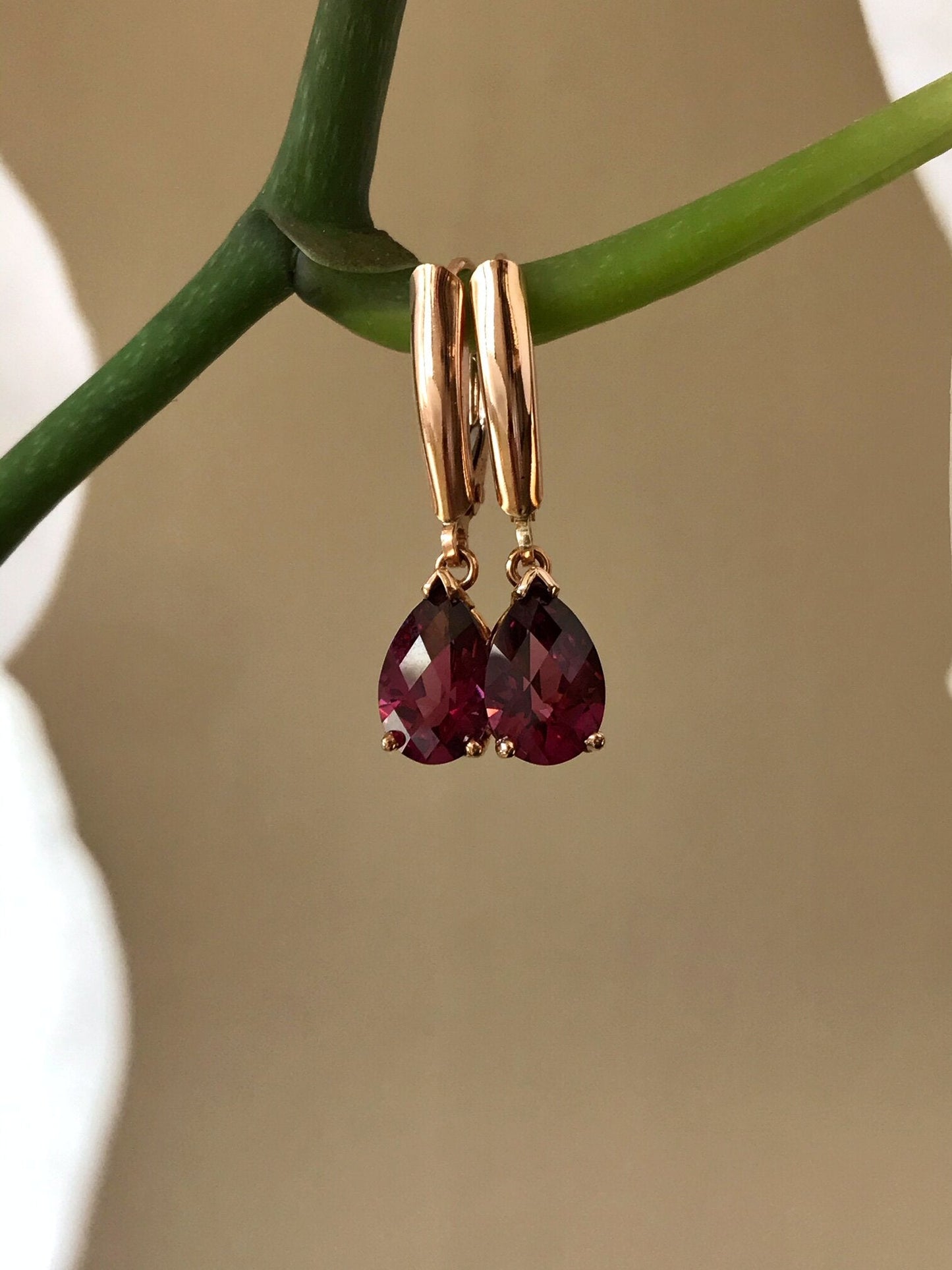 Photo of Checkerboard Rhodolite Garnet Dangles in a decorative scene, designed by , available at Plumb Gold & Plumb Silver