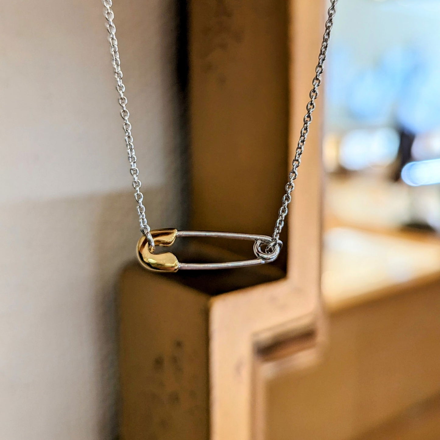 Photo of "Chic Pin" Necklace in a decorative scene, designed by , available at Plumb Gold & Plumb Silver