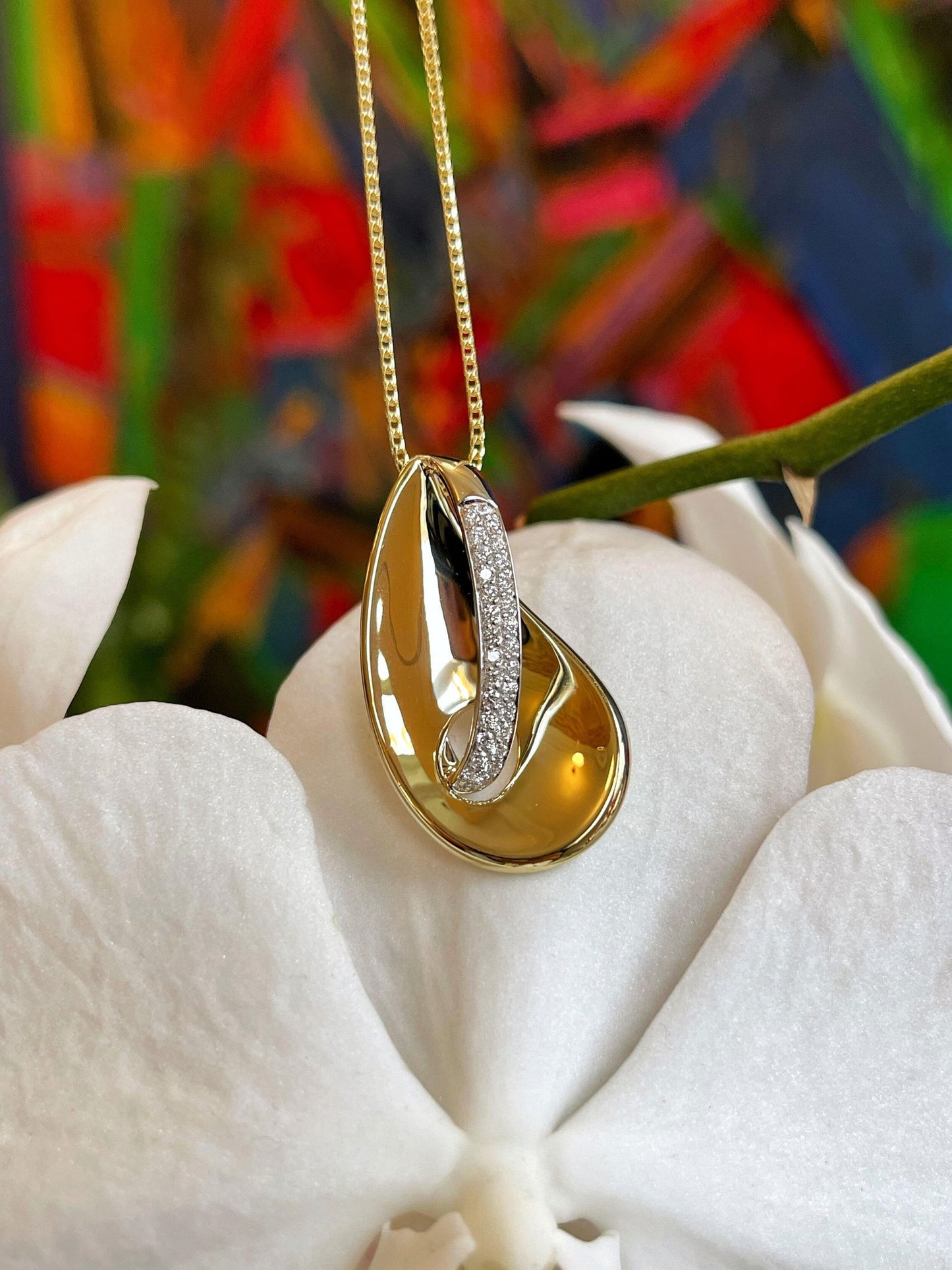 Photo of Concave Loop Pendant in a decorative scene, designed by , available at Plumb Gold & Plumb Silver