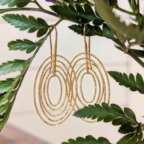 Photo of Concentric Oval Earrings in a decorative scene, designed by , available at Plumb Gold & Plumb Silver