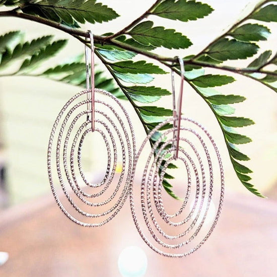 Photo of Concentric Oval Earrings in a decorative scene, designed by , available at Plumb Gold & Plumb Silver