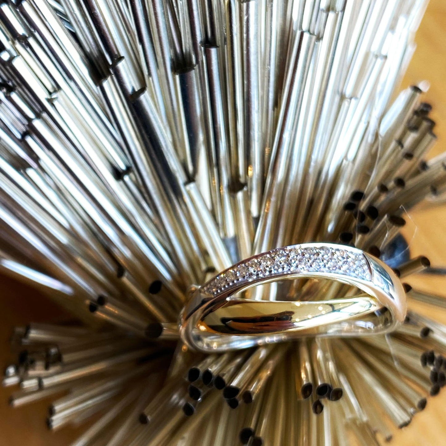 Photo of Crossover Ring with Diamond Accents in a decorative scene, designed by , available at Plumb Gold & Plumb Silver