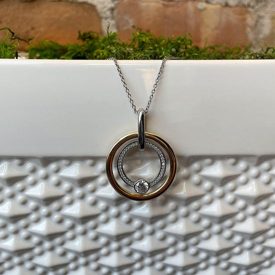 Photo of Cubic Zirconia Double Circle Pendant in a decorative scene, designed by , available at Plumb Gold & Plumb Silver
