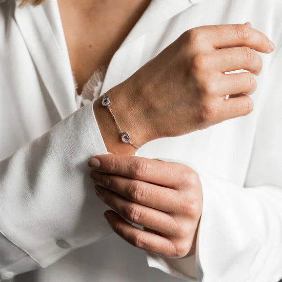 Photo of Cubic Zirconia Entwined Circles Station Bracelet in a decorative scene, designed by , available at Plumb Gold & Plumb Silver