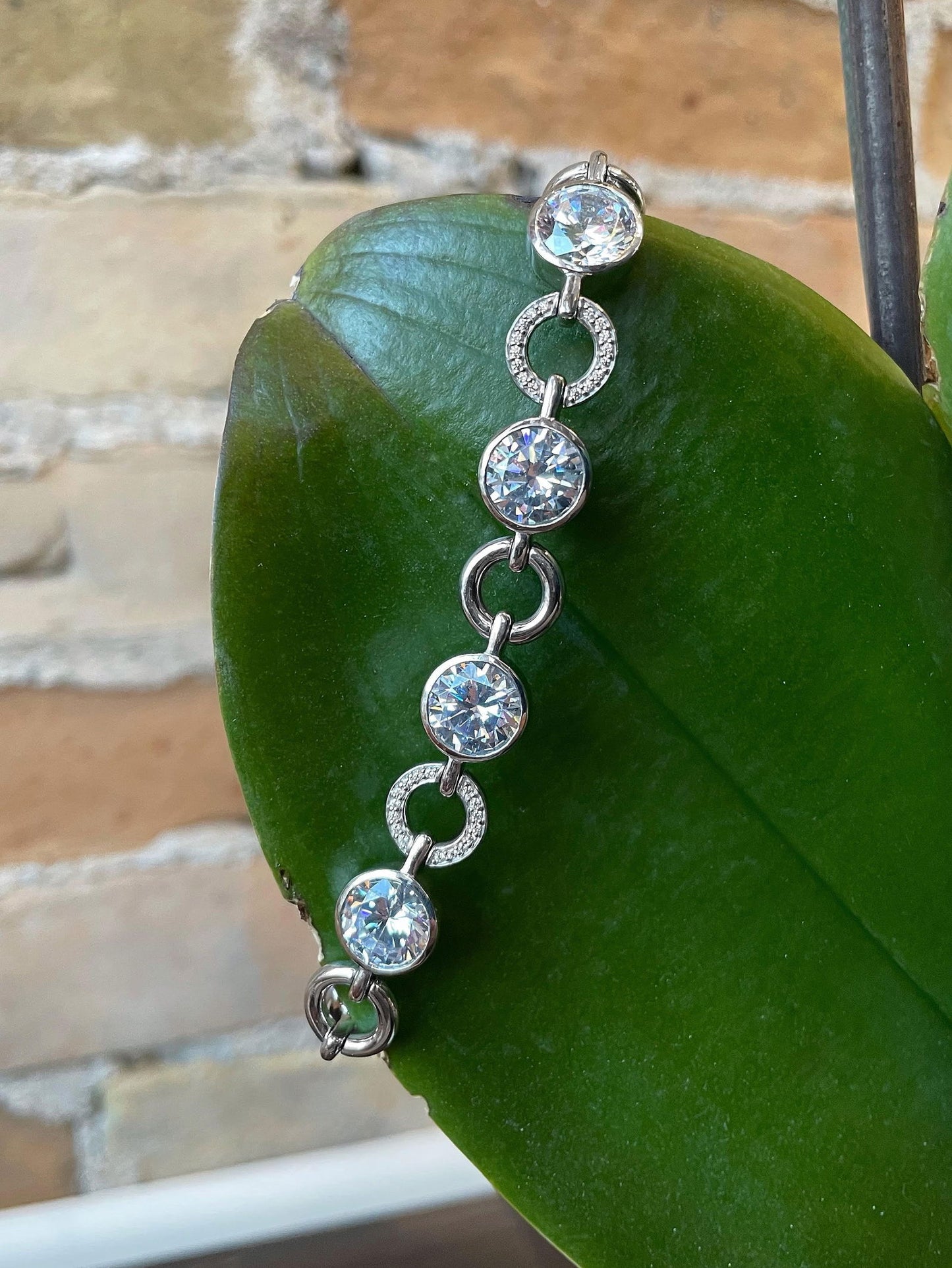 Photo of Cubic Zirconia Fancy Link Bracelet in a decorative scene, designed by , available at Plumb Gold & Plumb Silver